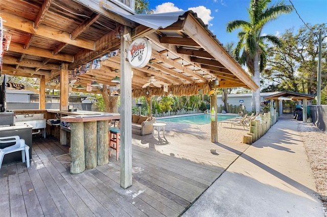 wooden terrace featuring a fenced in pool and an outdoor bar