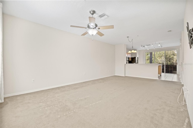 unfurnished living room with ceiling fan, light colored carpet, and rail lighting