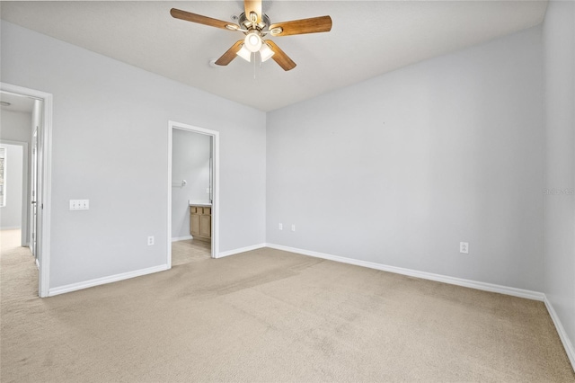 unfurnished bedroom with ceiling fan, light colored carpet, and connected bathroom