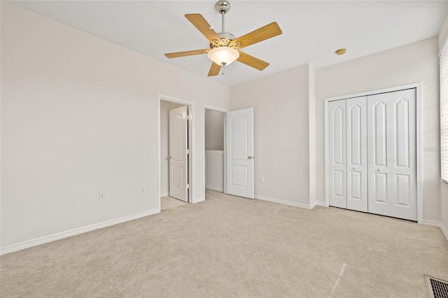 unfurnished bedroom with light carpet, ceiling fan, and a closet