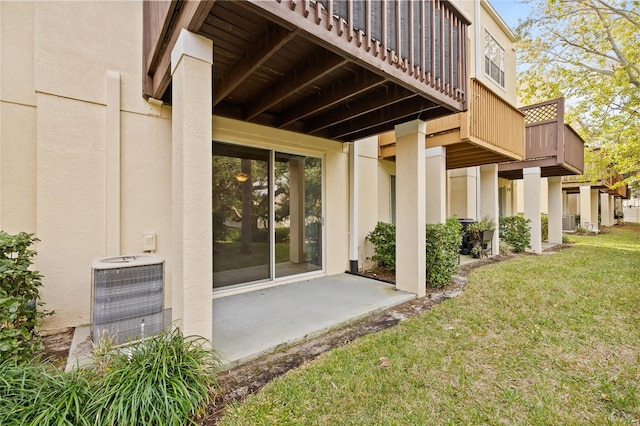 back of property featuring a balcony, a lawn, and central air condition unit