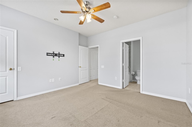 unfurnished bedroom with ceiling fan, light colored carpet, and connected bathroom