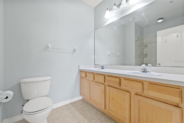 bathroom featuring tile patterned flooring, vanity, toilet, and tiled shower