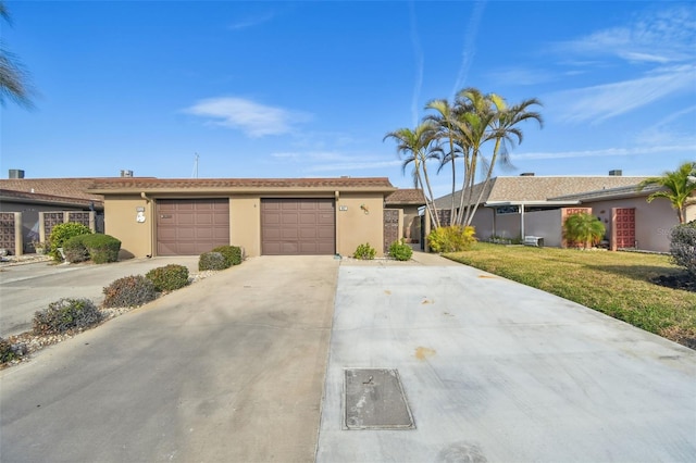 ranch-style home with a garage and a front lawn