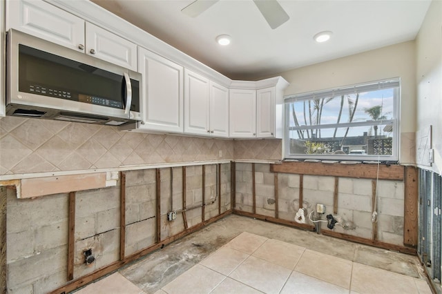 kitchen featuring decorative backsplash, ceiling fan, and white cabinets