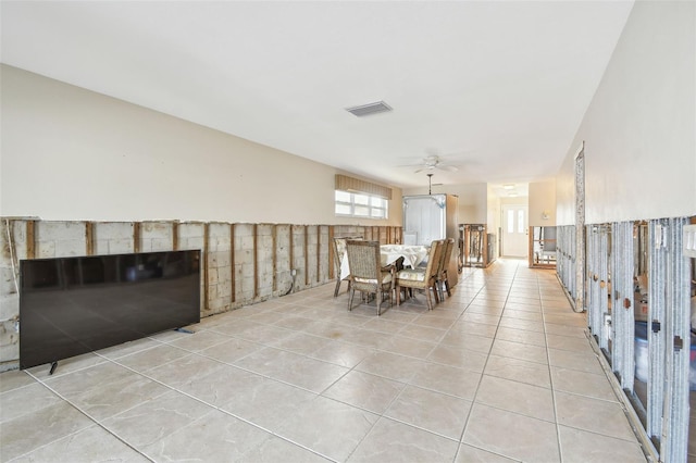 unfurnished dining area featuring ceiling fan and light tile patterned floors