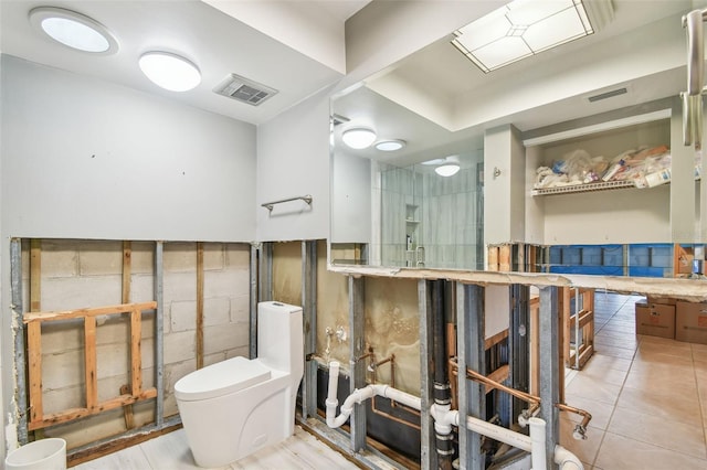 bathroom with toilet, tile patterned floors, and walk in shower