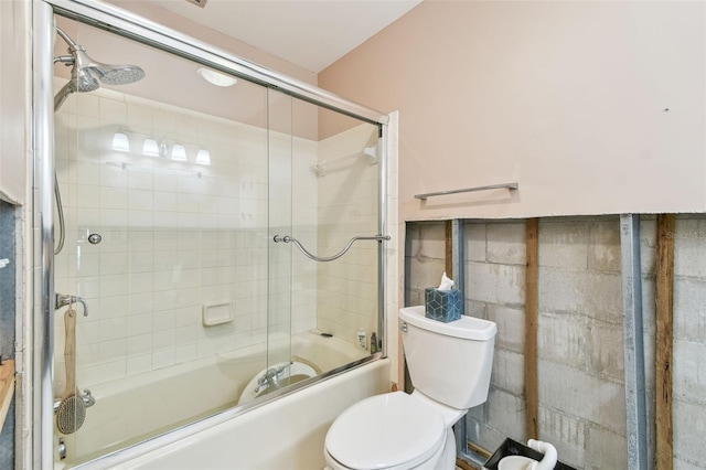 bathroom featuring bath / shower combo with glass door and toilet