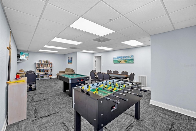 game room featuring dark colored carpet and a drop ceiling