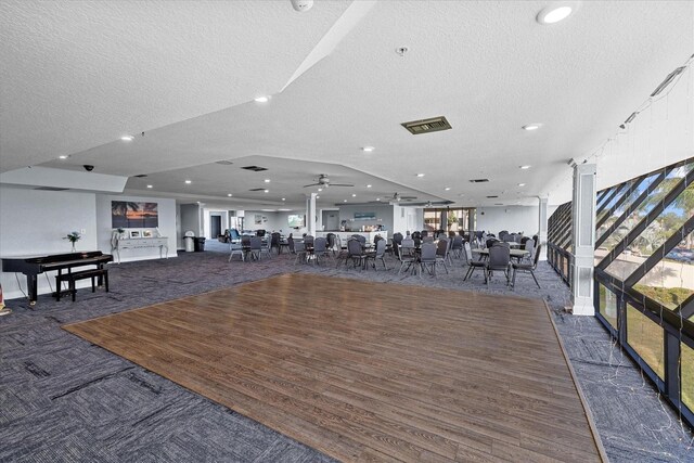 workout area featuring dark hardwood / wood-style flooring, a textured ceiling, and ceiling fan