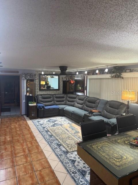 tiled living room featuring a textured ceiling