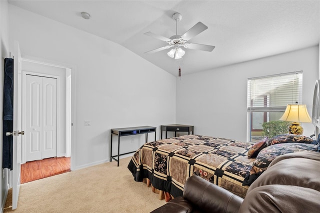 carpeted bedroom with ceiling fan, a closet, and lofted ceiling