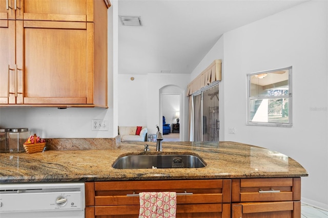 kitchen featuring light stone countertops, stainless steel built in refrigerator, white dishwasher, and sink