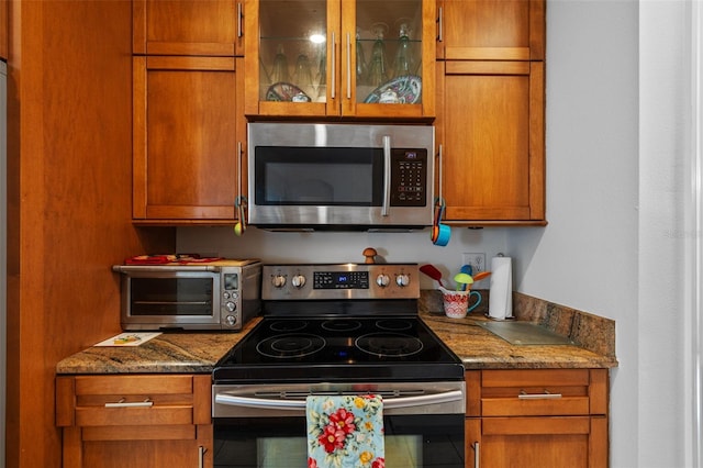 kitchen featuring appliances with stainless steel finishes and dark stone countertops