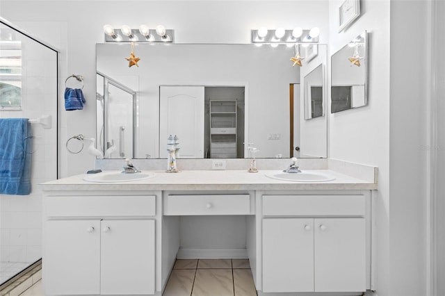 bathroom with tile patterned flooring, vanity, and a shower with door