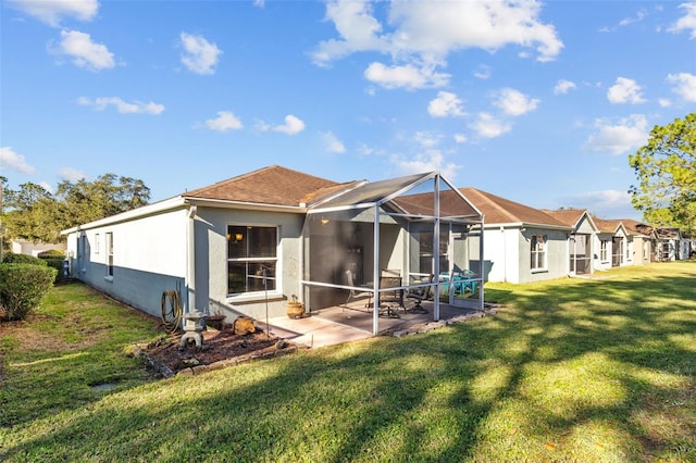 rear view of property with a patio, glass enclosure, and a lawn