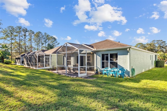 back of property with a yard, a patio, and a lanai