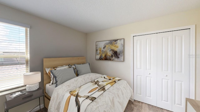 carpeted bedroom featuring a textured ceiling and a closet