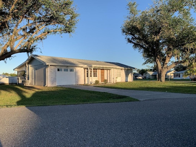 single story home with a garage and a front lawn