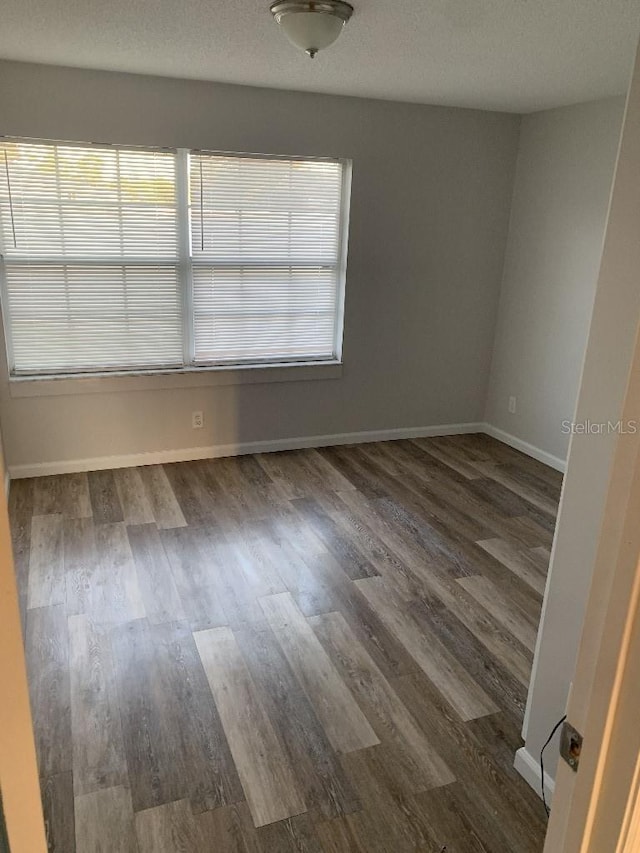 spare room with dark wood-type flooring