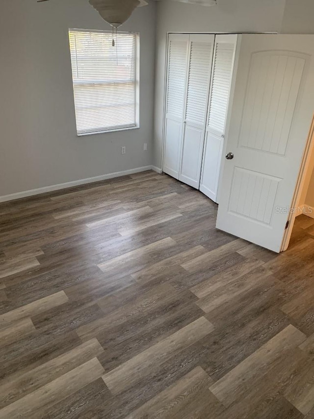 unfurnished bedroom with dark hardwood / wood-style floors and a closet