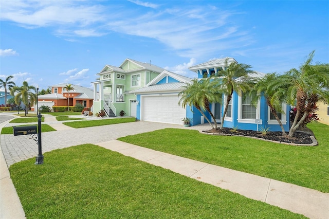 6408 Key Island Ave, Apollo Beach, FL 33572 - view of front facade with decorative driveway, a front lawn, metal roof, a garage, and a standing seam roof