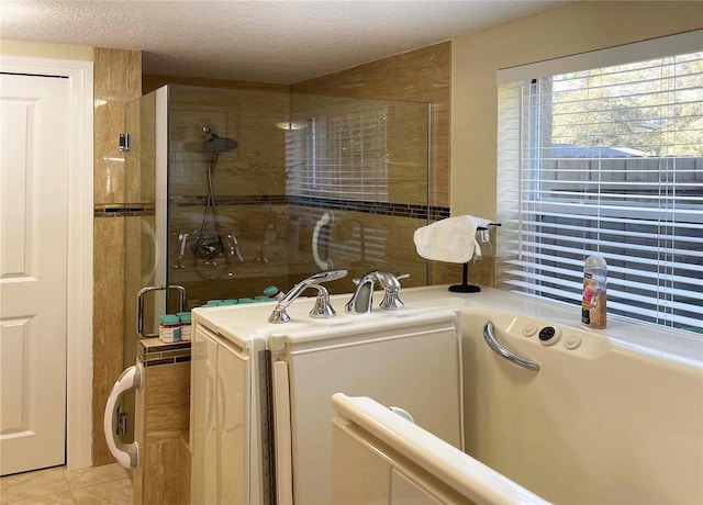 laundry area with a textured ceiling and light tile patterned flooring