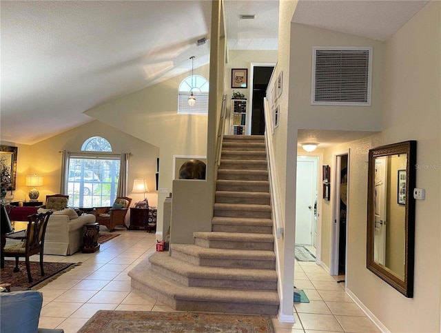 stairs with tile patterned flooring and vaulted ceiling