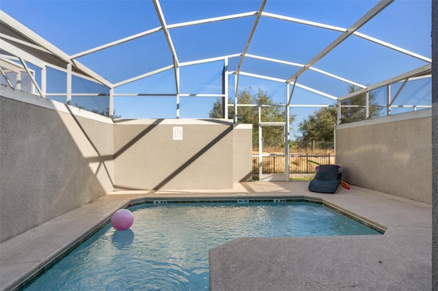 view of swimming pool featuring a patio area and glass enclosure