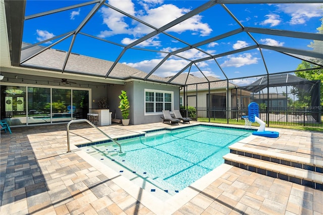 view of swimming pool with a patio area, ceiling fan, and a lanai