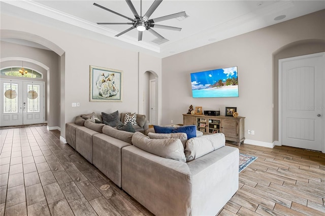 living room featuring crown molding, french doors, and ceiling fan with notable chandelier