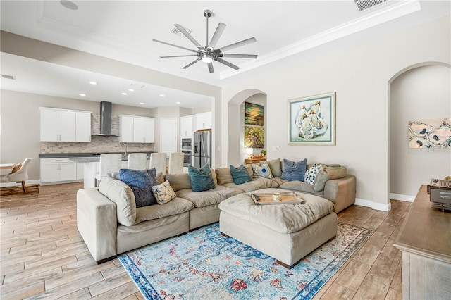 living room with ceiling fan and crown molding