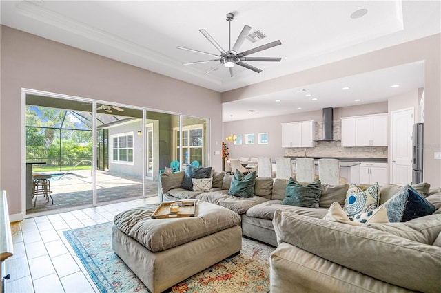 living room with a raised ceiling and ceiling fan