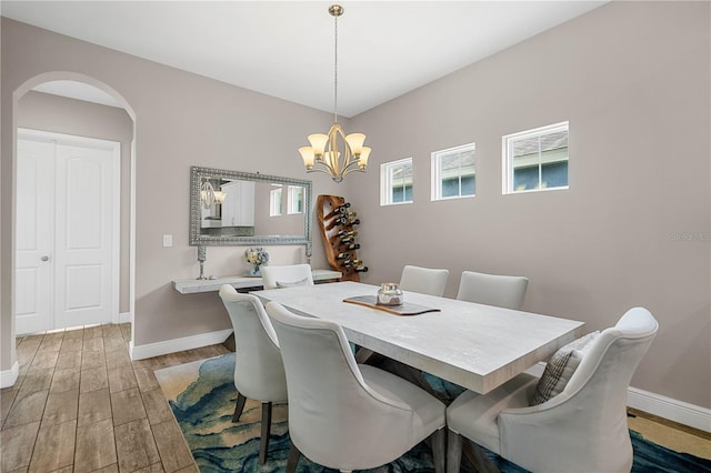 dining space featuring an inviting chandelier and hardwood / wood-style flooring