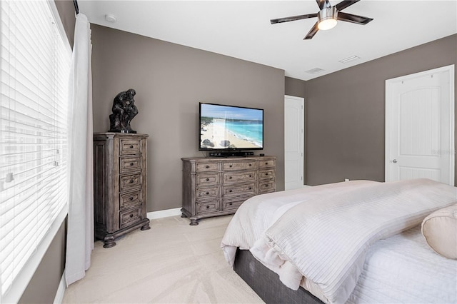 bedroom with ceiling fan, light carpet, and multiple windows