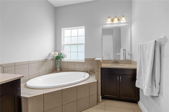 bathroom with tiled bath, tile patterned flooring, and vanity