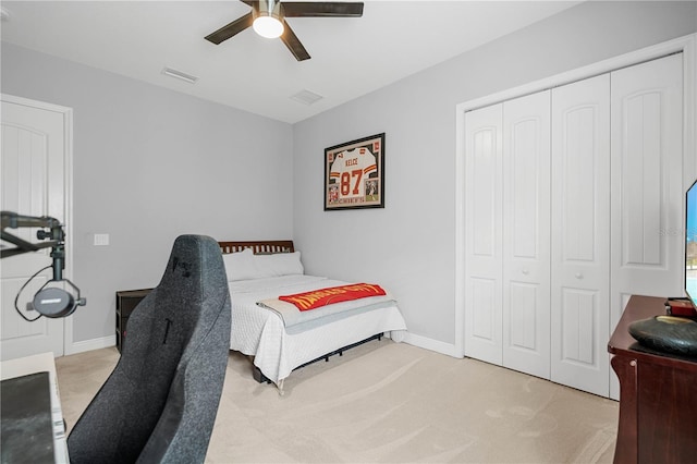 carpeted bedroom featuring ceiling fan and a closet