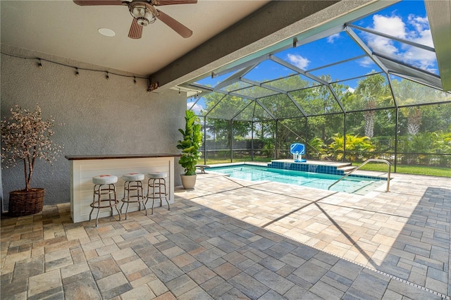 view of pool with ceiling fan, a lanai, a bar, and a patio