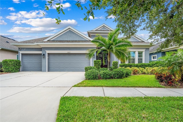 ranch-style home with stucco siding, a front lawn, concrete driveway, and a garage