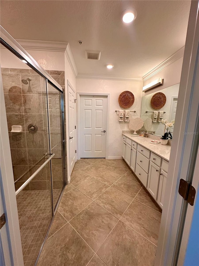 bathroom with vanity, a shower with shower door, and ornamental molding