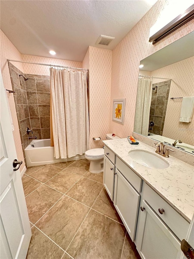 full bathroom featuring vanity, a textured ceiling, shower / bath combo with shower curtain, tile patterned flooring, and toilet