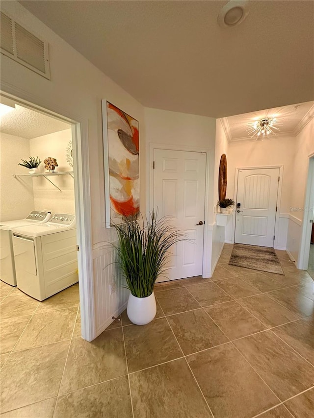 hall with washing machine and dryer and crown molding