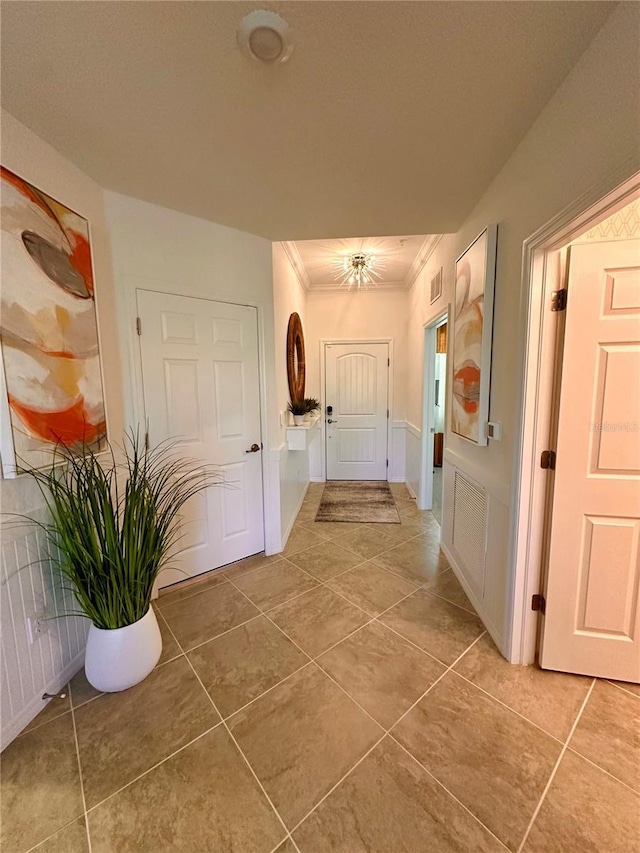 corridor with tile patterned flooring and crown molding