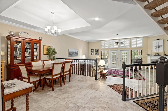 dining space featuring a raised ceiling, crown molding, and a notable chandelier