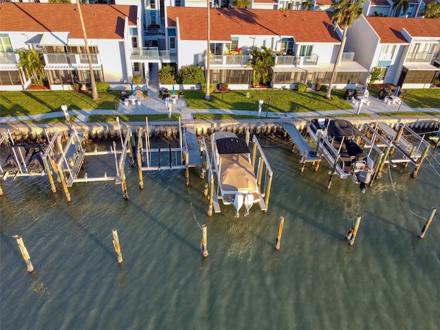 view of dock with a lawn and a water view