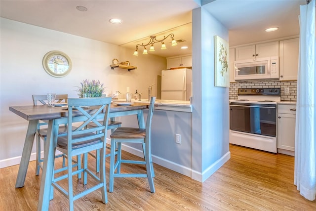 kitchen with white cabinets, white appliances, tasteful backsplash, and light hardwood / wood-style floors