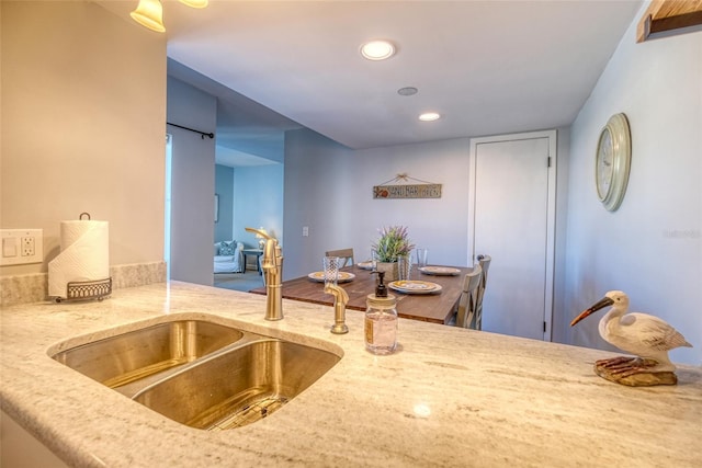 kitchen featuring light stone countertops and sink