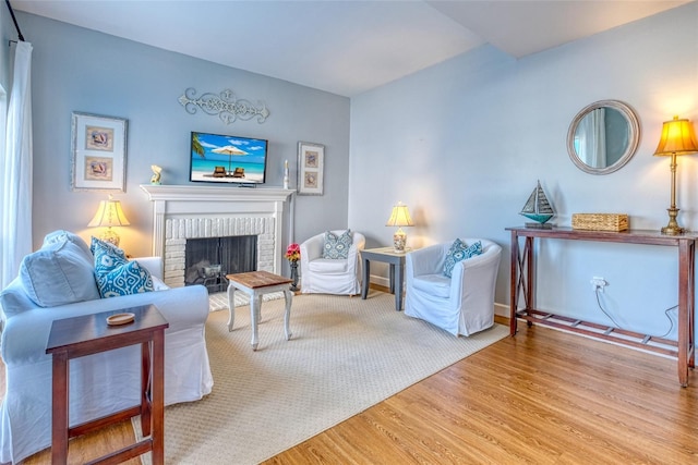 living room with a fireplace and light wood-type flooring