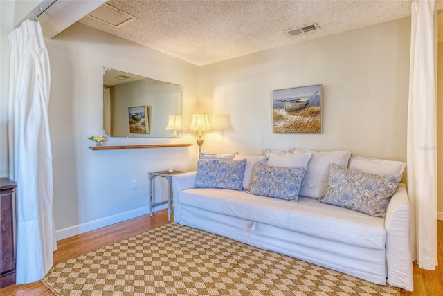 living room featuring wood-type flooring and a textured ceiling