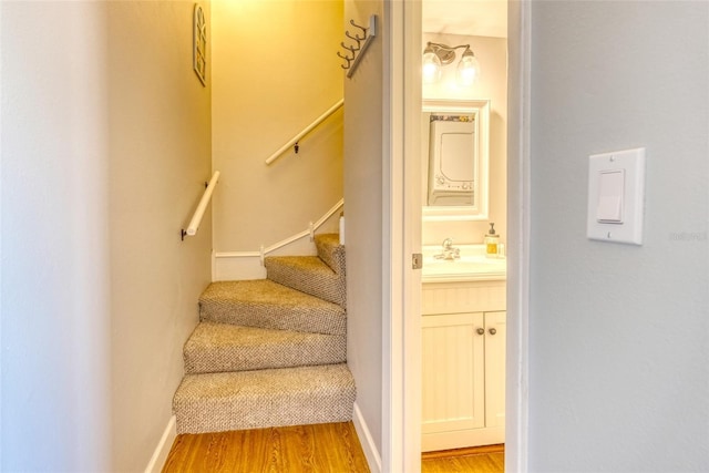 staircase with wood-type flooring and sink